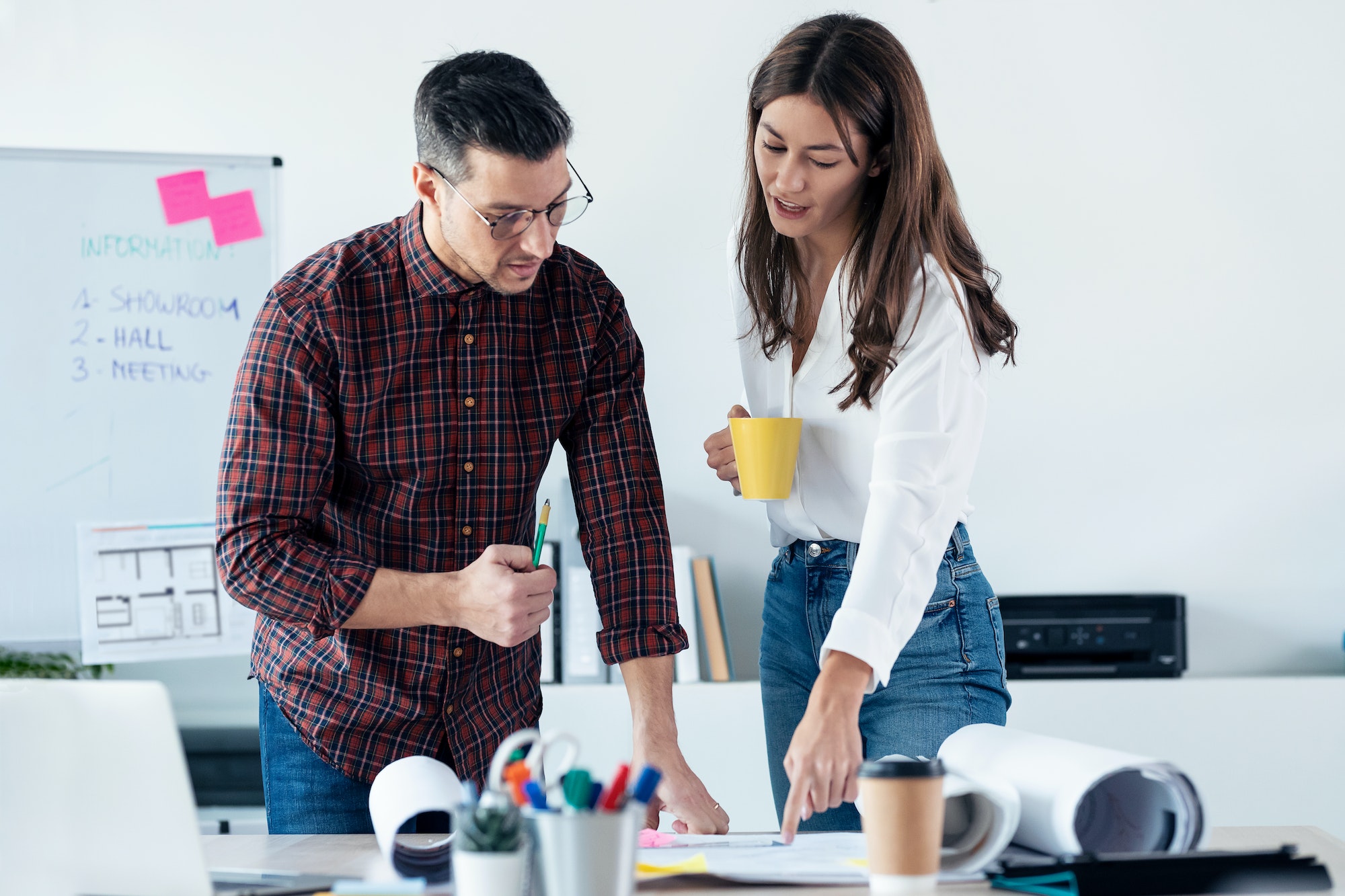 Two entrepreneurs working while talking of their new design business together in the office.